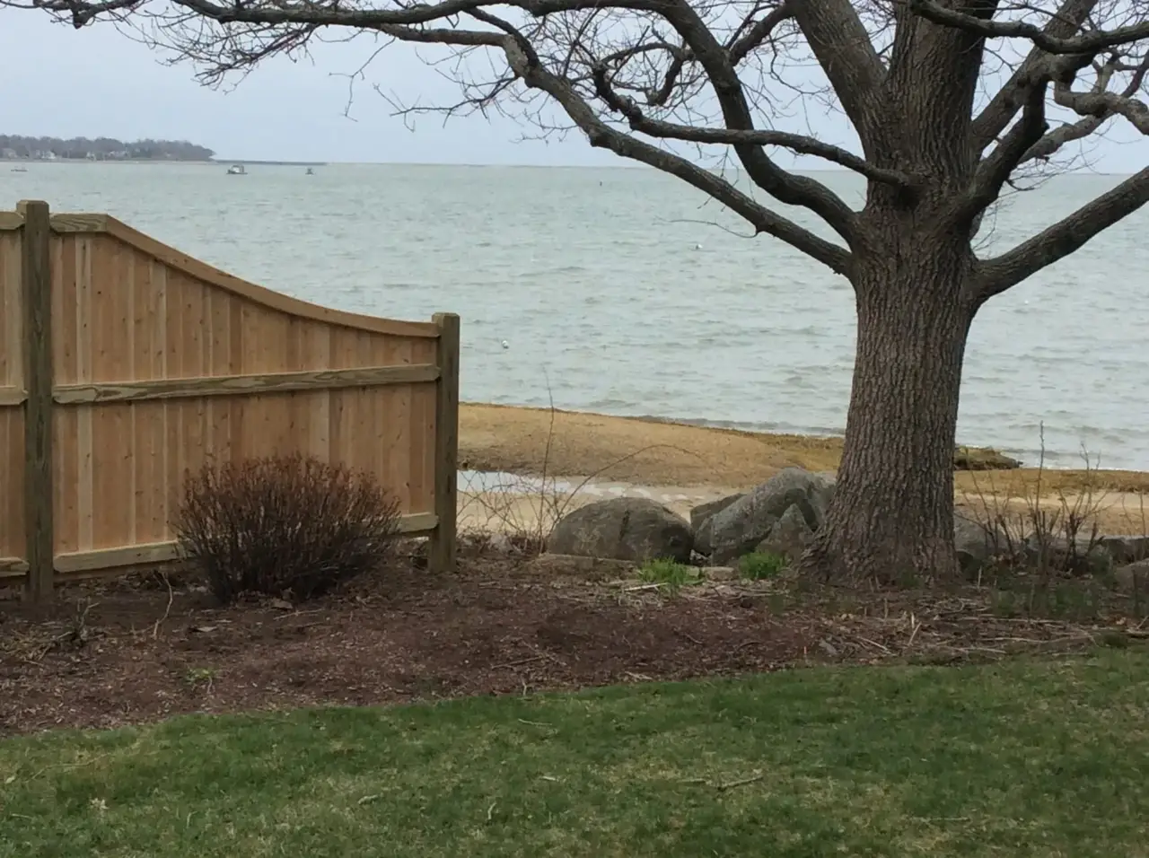 Cedar fencing installed along a wooded residential property line on the South Shore
